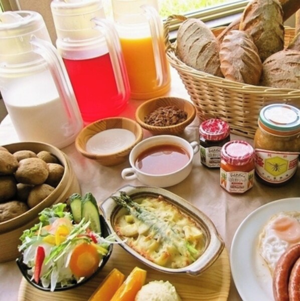 A breakfast table with various food items, including bread, eggs, and a salad.
