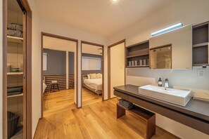 Een moderne badkamer met een grote spiegel, een wastafel en een douche.