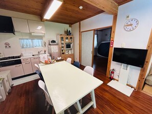 Une cuisine de taille réduite avec un coin repas, un plafond en bois et une horloge au mur.
