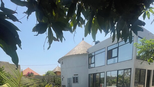 A modern two-story house with a swimming pool, surrounded by a well-maintained lawn and a palm tree. - Charming 3-bedroom villa with Wifi, AC in lovely Somone near Saly. (Somone)