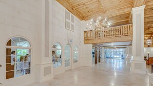 A spacious hotel lobby with high ceilings, large windows, and a wooden balcony. - Palm Beach Condo, Poolside Gem! Walk to Beach (Palm Beach)