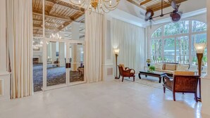 Una habitación amplia con candelabro, ventanas grandes y vistas al exterior.