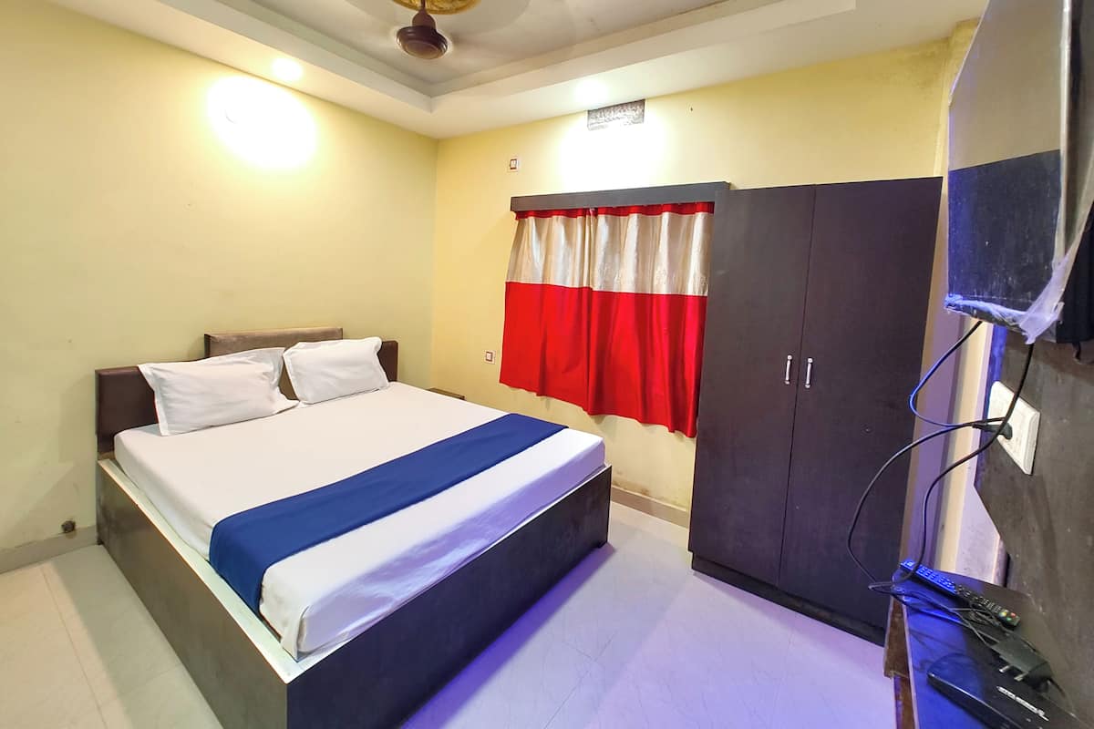 Une chambre à coucher comprenant un lit, une armoire, un ventilateur de plafond et un téléviseur.
