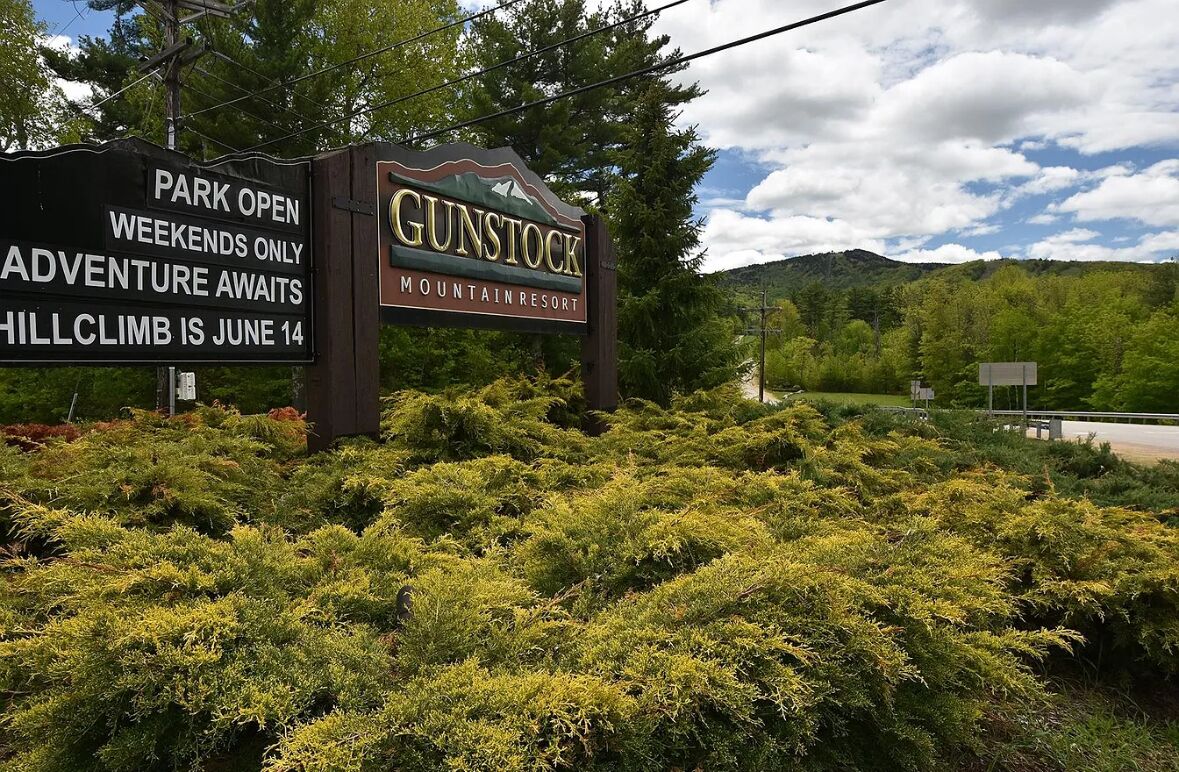 Segnaletica per il Gunstock Mountain Resort con un messaggio sull'apertura del parco nei fine settimana e una gara di salita in montagna il 14 giugno.