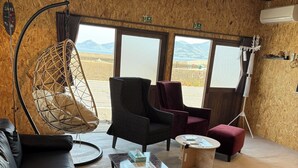 Une pièce confortable avec un canapé, des fauteuils, un fauteuil suspendu et une table.