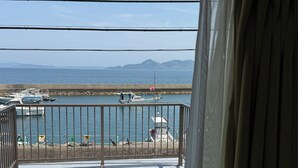 Un balcon avec vue sur la mer et les montagnes.