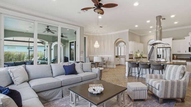 A spacious living area with a large sofa, a coffee table, and a dining area with bar stools.