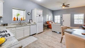 A modern kitchen with white cabinets, a refrigerator, and a dining area with a table and chairs. - Apartment 2 Mi to Chase Field & PHX Arena! (Phoenix)