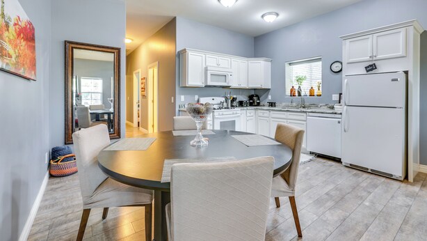 A modern kitchen with white cabinets, a dining table with chairs, and a refrigerator. - Apartment 2 Mi to Chase Field & PHX Arena! (Phoenix)