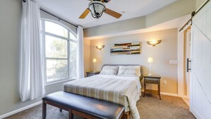 A bedroom with a bed, bench, ceiling fan, bedside lamps, and a window with curtains. - 1 Mi to Tempe Beach Park: Well-Equipped Condo! (Tempe)