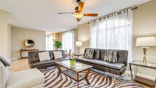 A modern living room with a sofa, armchair, and coffee table, featuring a zebra-patterned rug and a ceiling fan. - 1 Mi to Tempe Beach Park: Well-Equipped Condo! (Tempe)