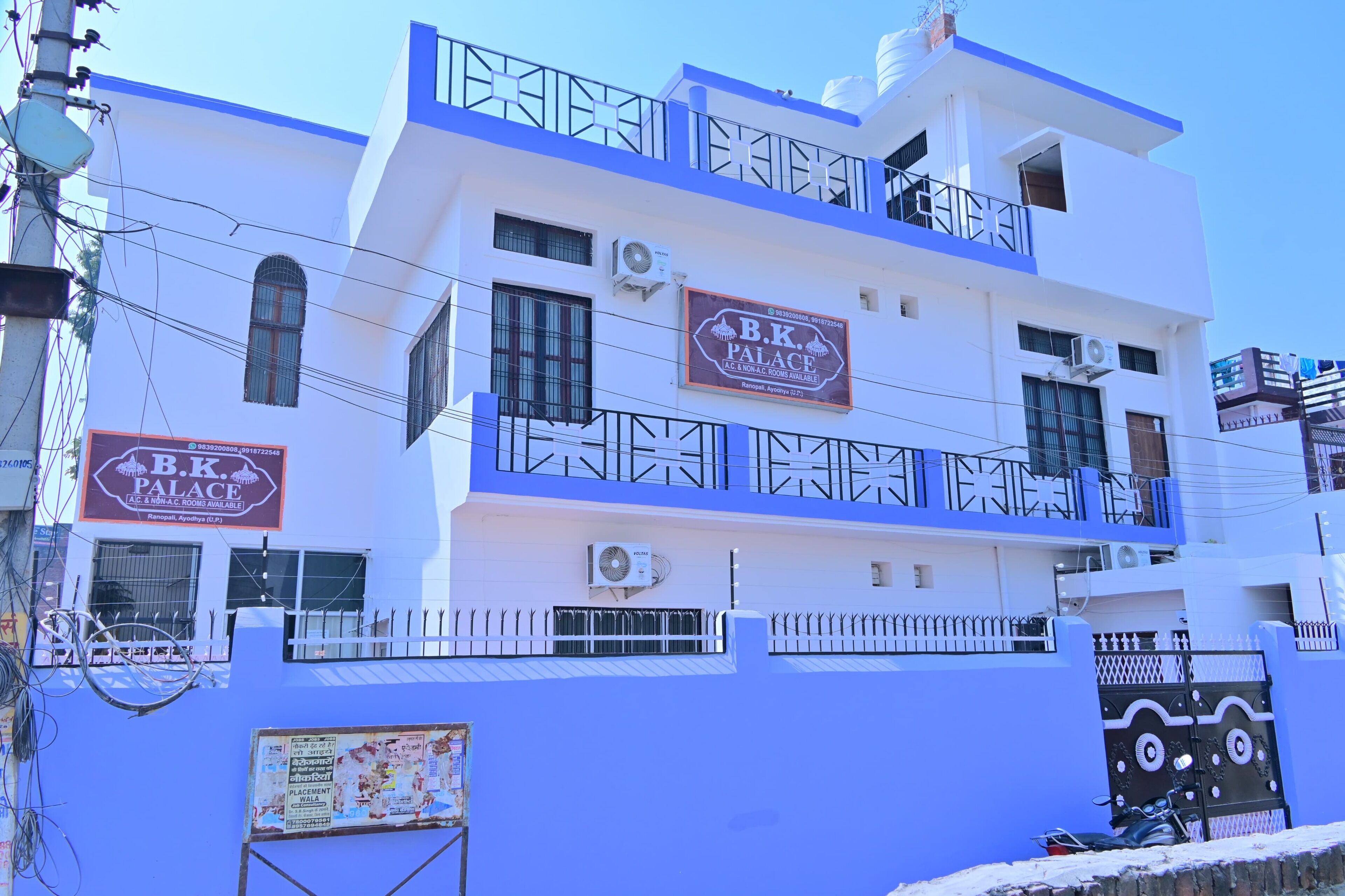 A multi-story building with a sign for B.K. Palace, featuring balconies and a gated entrance.