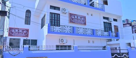 A multi-story building with a sign for B.K. Palace, featuring balconies and a gated entrance.