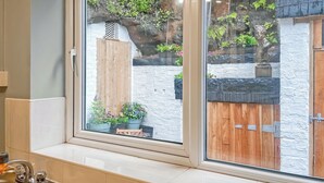 A bathroom with a window overlooking a garden.