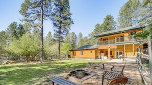 A cabin with a deck, a fire pit, and outdoor seating. - Game Nights in Pine's Winter Woods: Cozy Cabin (Pine)