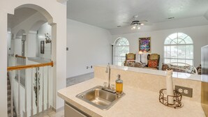 A kitchen with a stainless steel sink, a ceiling fan, and a window with a view of the outside. - 12 Mi to Dtwn Houston: Family-Friendly Home! (Houston)