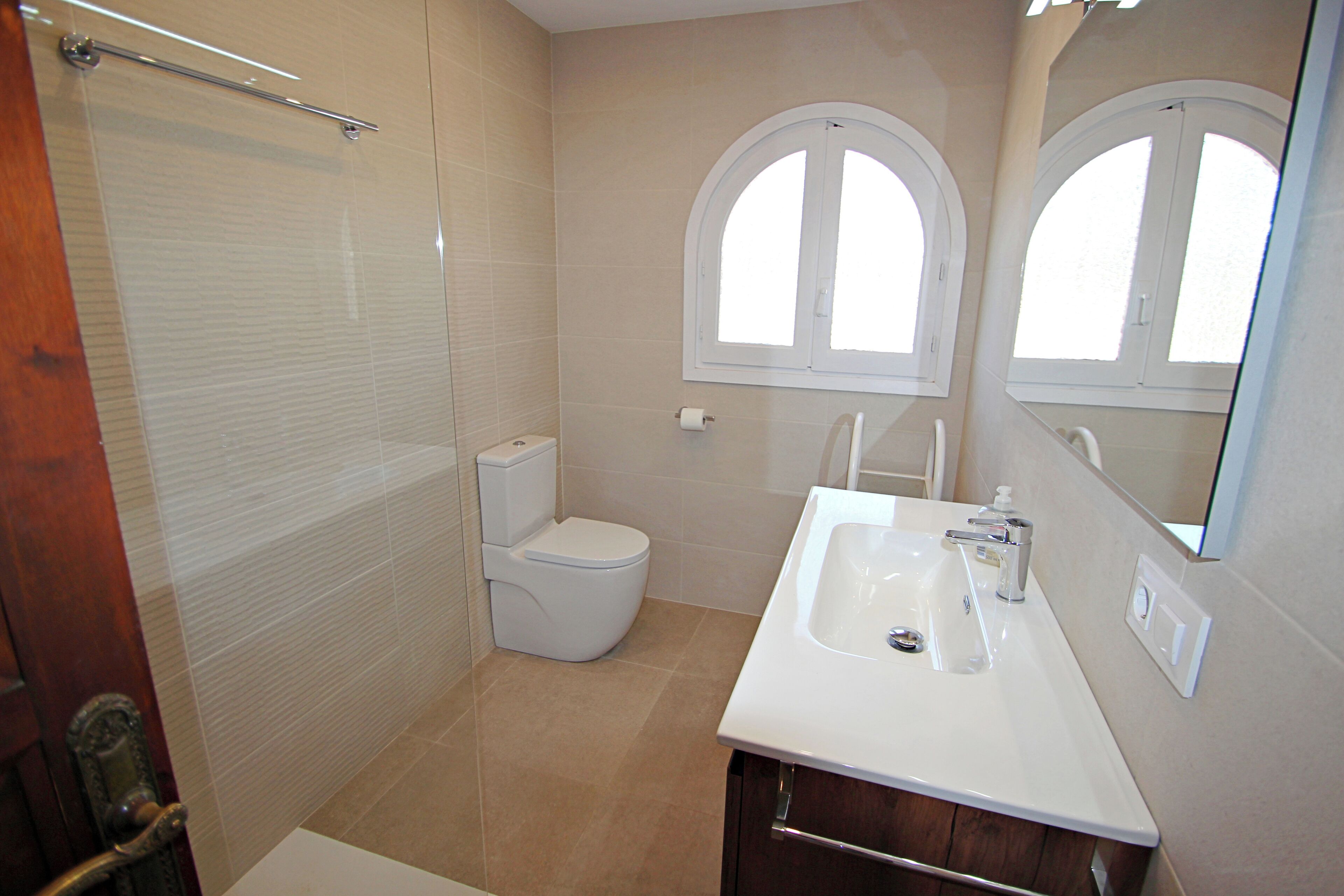 A bathroom with a toilet, a sink, and a shower.