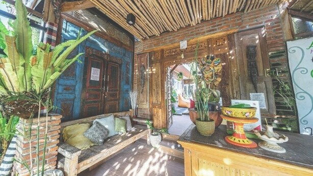 A rustic interior with a wooden ceiling, a brick wall, and a wooden bench. - The shortcut rooms (Canggu)