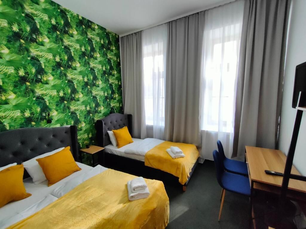 Una habitación de hotel con dos camas, un escritorio y una silla.