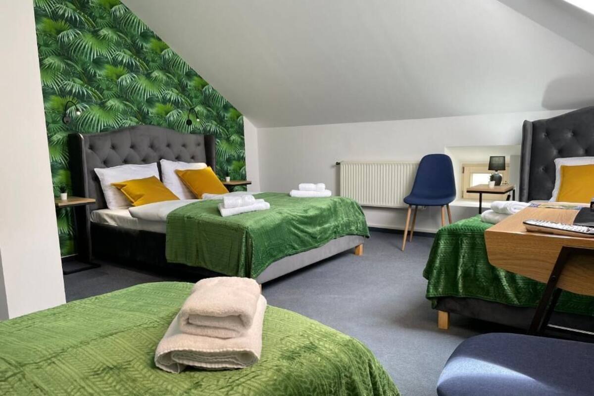 Ein Hotelzimmer mit zwei Betten, einem Schreibtisch, einem Stuhl und einer Heizung.