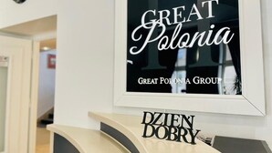 Een bord met de tekst 'GREAT Polonia' en 'GREAT POLONIA GROUP', met daaronder een bordje met 'DZIEN DOBRY'.