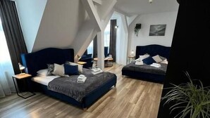 Een moderne loft slaapkamer met een groot bed, een kleiner bed en een werkplek.