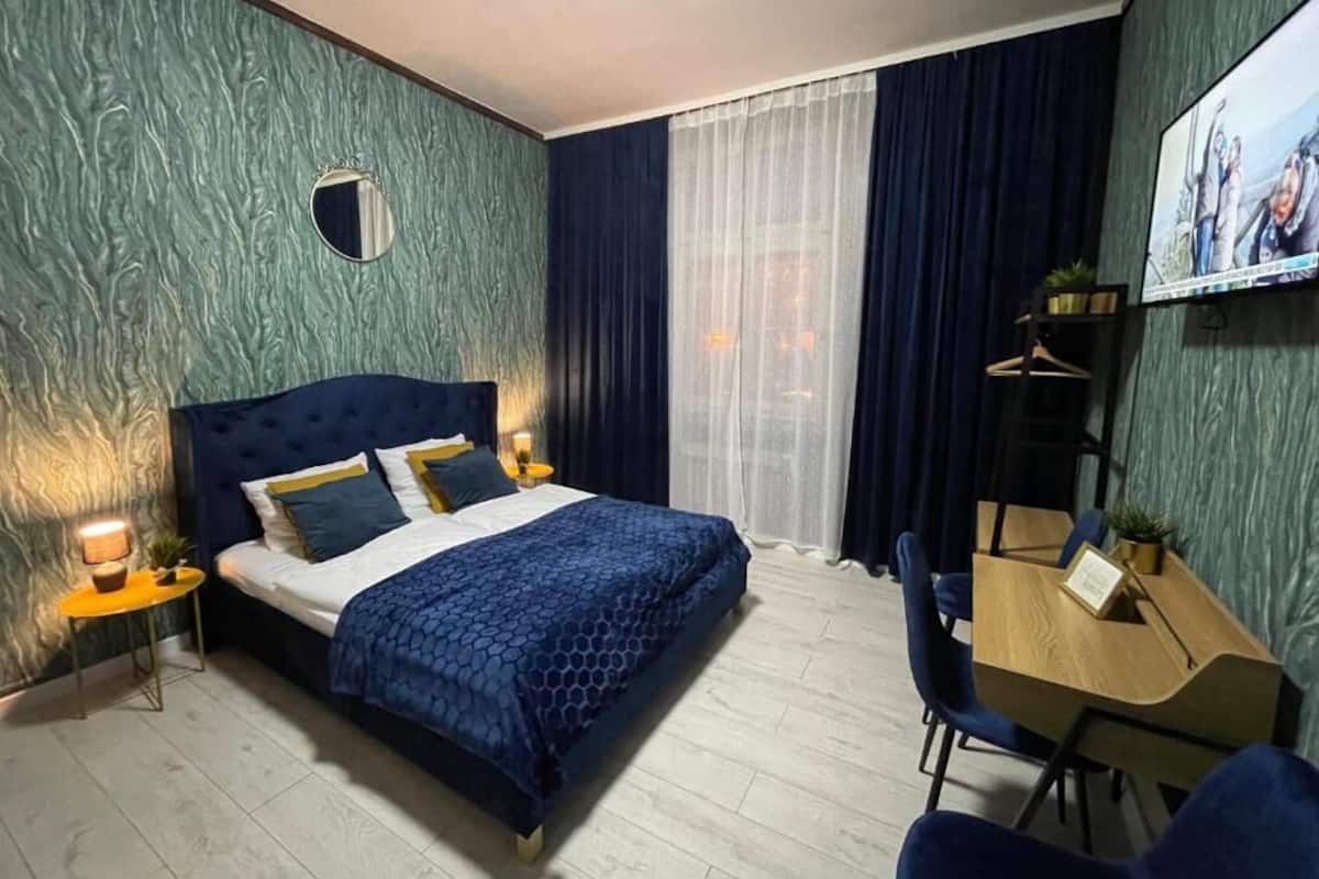 Ein modernes Hotelzimmer mit einem großen Bett, einem Schreibtisch und einem Fernseher.