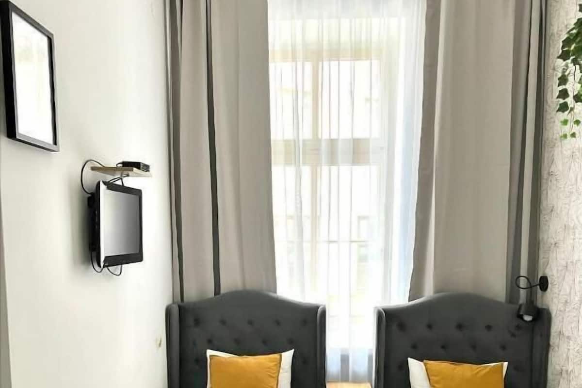 Ein Hotelzimmer mit zwei Betten, einem Schreibtisch und einem Stuhl.