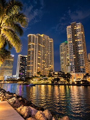 A waterfront view of high-rise buildings with a reflection in the water.