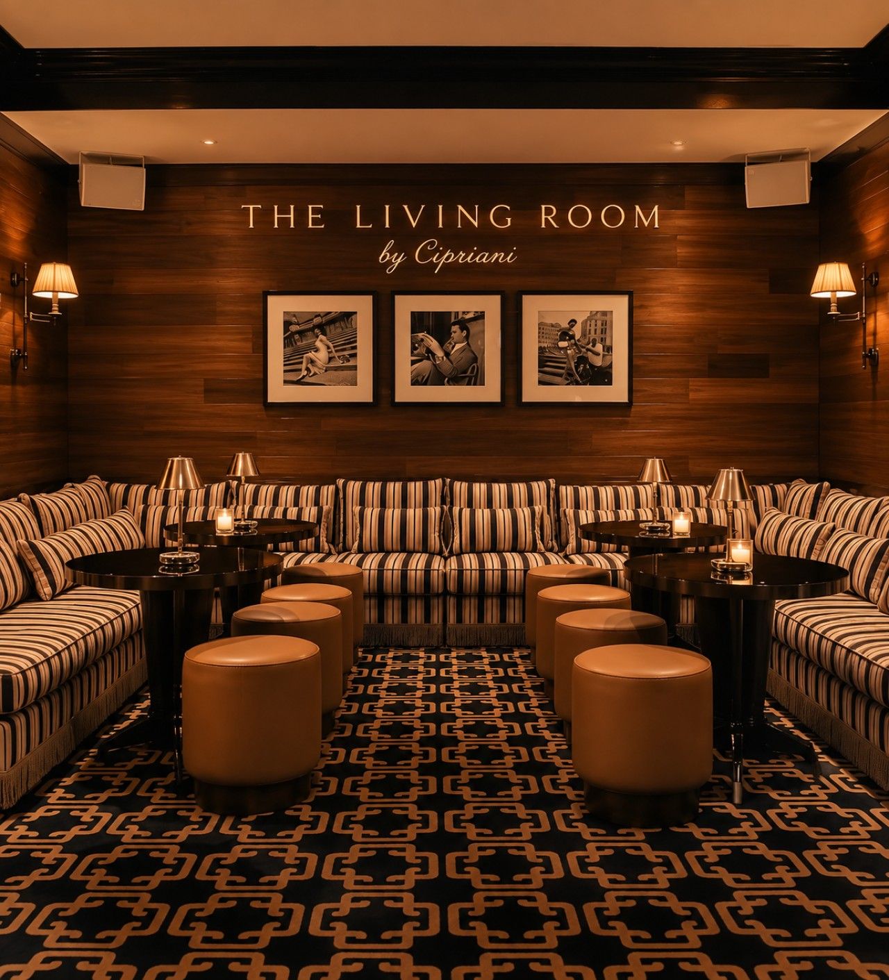 A living room with striped sofas, round tables, and wall-mounted lamps.