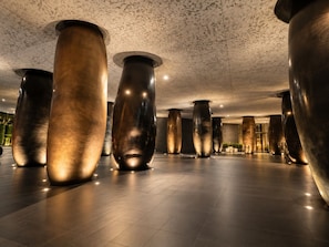 A spacious lobby with large, metallic cylindrical columns and a polished floor.