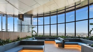 A modern interior with large windows, seating areas, and a view of the cityscape. - 12- Comfy 2B in the Heart of CBD (Brisbane City)