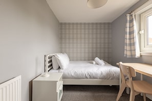 A bedroom with a bed, a desk, and a chair. - Fraser Avenue (No 16) (St Andrews)