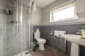 A modern bathroom with a glass-enclosed shower, a toilet, and a sink. - Fraser Avenue (No 16) (St Andrews)