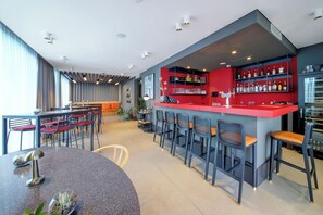 Enjoy a drink at the stylish bar with comfortable seating and a selection of bottles on display.