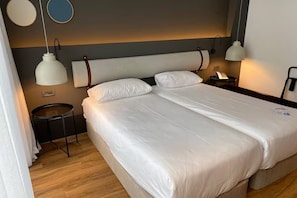 Relax in a spacious room with a large bed, nightstand, and lamp.