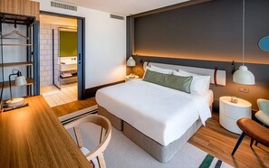 Relax in a serene space with a large bed, bedside table, and comfortable chair.