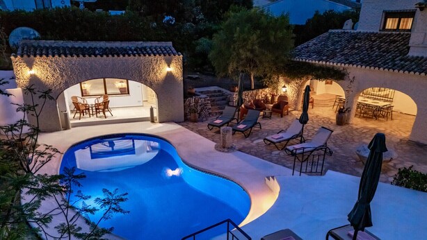 A swimming pool with lounge chairs and a patio area.