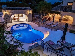 Une piscine avec des chaises longues et un espace patio.