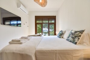 Une chambre avec un lit, un téléviseur fixé au mur et une fenêtre donnant sur un beau paysage.