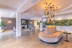 Relax in style with a comfortable sofa, fireplace, and lush greenery.