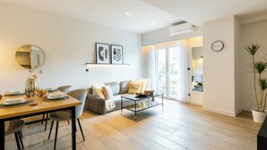 Una sala moderna con una mesa de comedor de madera, un sofá gris y una mesa de centro.