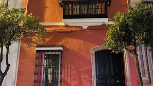 A building with a red facade, black iron window frames, and a black door.