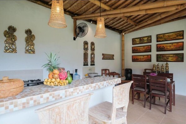 Enjoy meals in a well-appointed kitchen with a central island, dining area, and framed artwork.