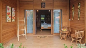 Una cabaña de madera con una cama, una escalera y una pequeña mesa con fruta.