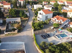 An aerial view of a residential area with houses, a swimming pool, and a parking lot. - Apartments Franica With Heated Pool and Hot-tub (Privlaka)