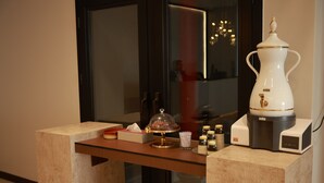 A reception desk with a coffee machine, a glass display case, and a small table with a candle and a bottle of perfume. - Palm Core Hotel Al Rabwah (Riyadh)