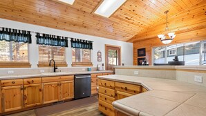 A kitchen with wooden cabinets, a dishwasher, and a large island with a countertop.