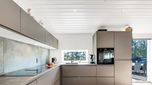 A modern kitchen with a large window, built-in appliances, and a wooden floor. - "Agnes" - 900m from the sea by Interhome (Ringkøbing)