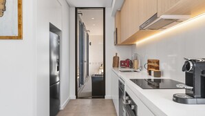 Eine moderne Küche mit Einbauofen, Kaffeemaschine und Holzausstattung.